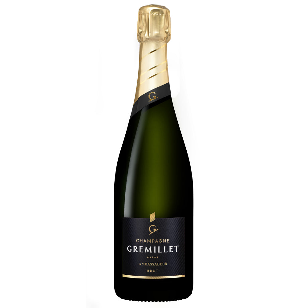 A bottle of Gremillet Champagne, featuring a dark green glass bottle with a gold foil top and a black label with gold lettering.