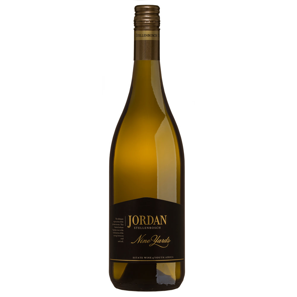 A bottle of Jordan Nine Yards Chardonnay white wine. It has a black label with gold writing and a brown and gold screw cap. All set on a white background.