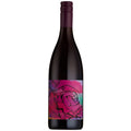 A dark glass wine bottle with a colorful floral label featuring a pink rose on a vibrant pink, purple, and blue watercolor background, topped with a dark purple capsule.